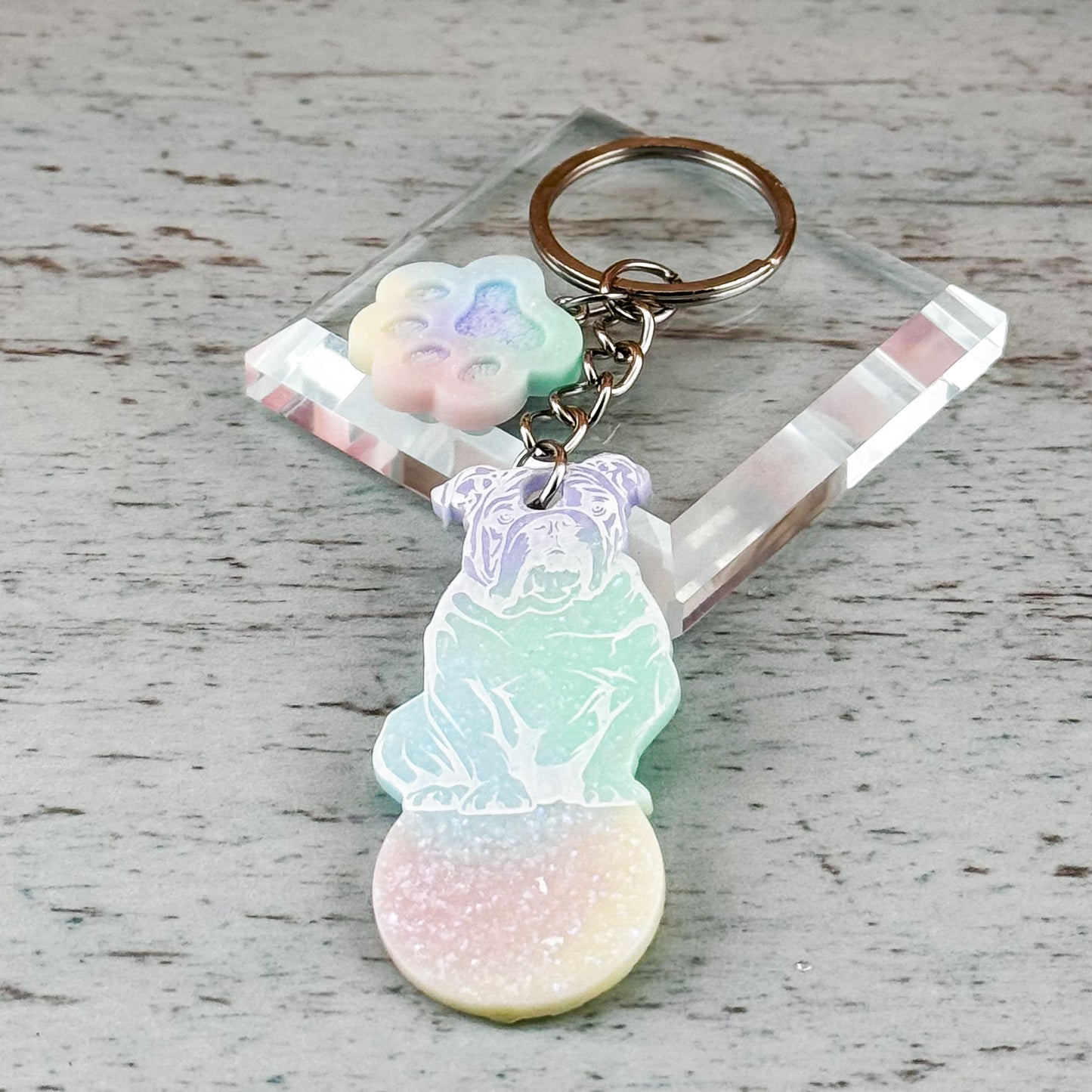 Nahaufnahme des Wagenlösers mit Bulldoggen-Motiv in sanften Regenbogenfarben auf Glasunterlage – ohne Stempel, zur besseren Detailerkennung der Oberfläche und Struktur.