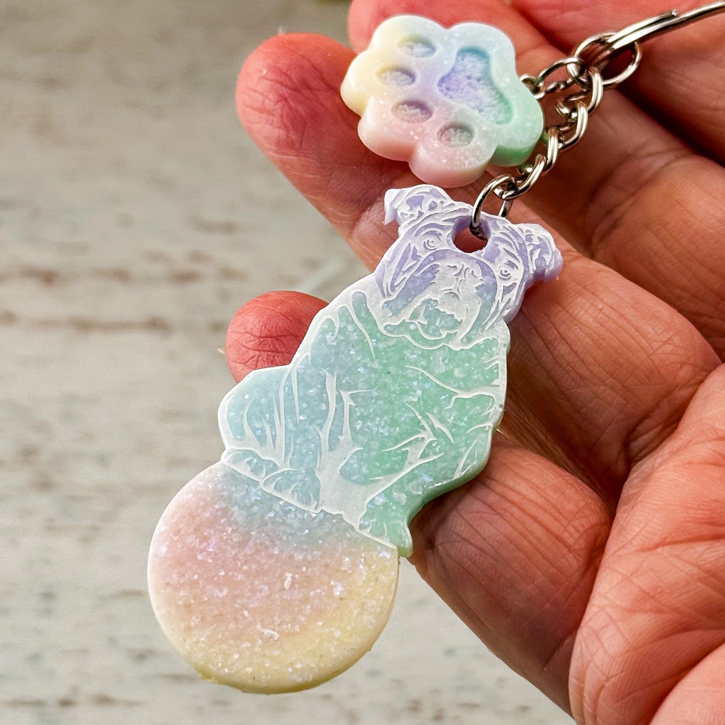 Wagenlöser mit Bulldoggen-Motiv in einer Hand gehalten – Größenvergleich des handgefertigten Resin-Unikats mit Pfötchendetail zur besseren Einschätzung.