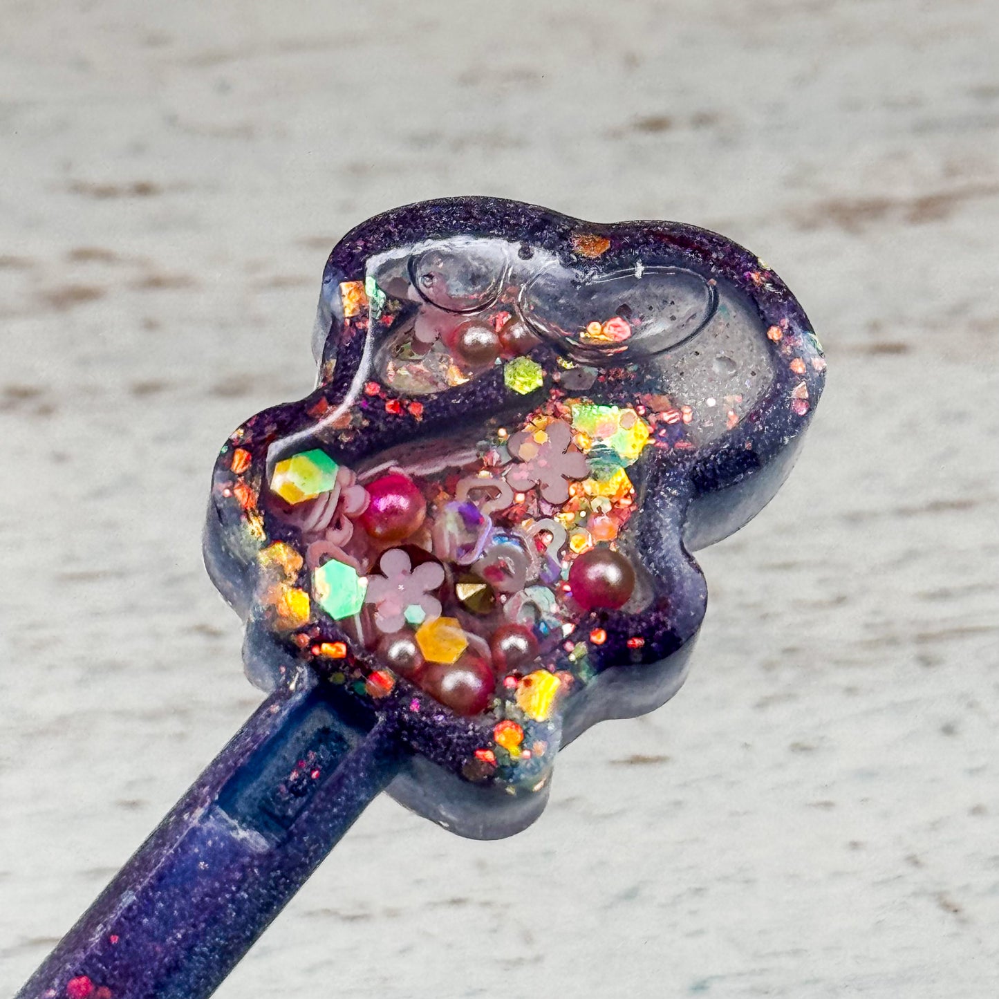 Nahaufnahme des transparenten Hasen-Shakers mit beweglichem Glitzer, eingefasst im lila Resin-Stift